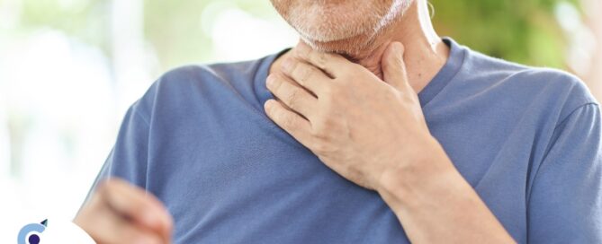 An older adult holds his throat representing dysphagia which can affect senior health.