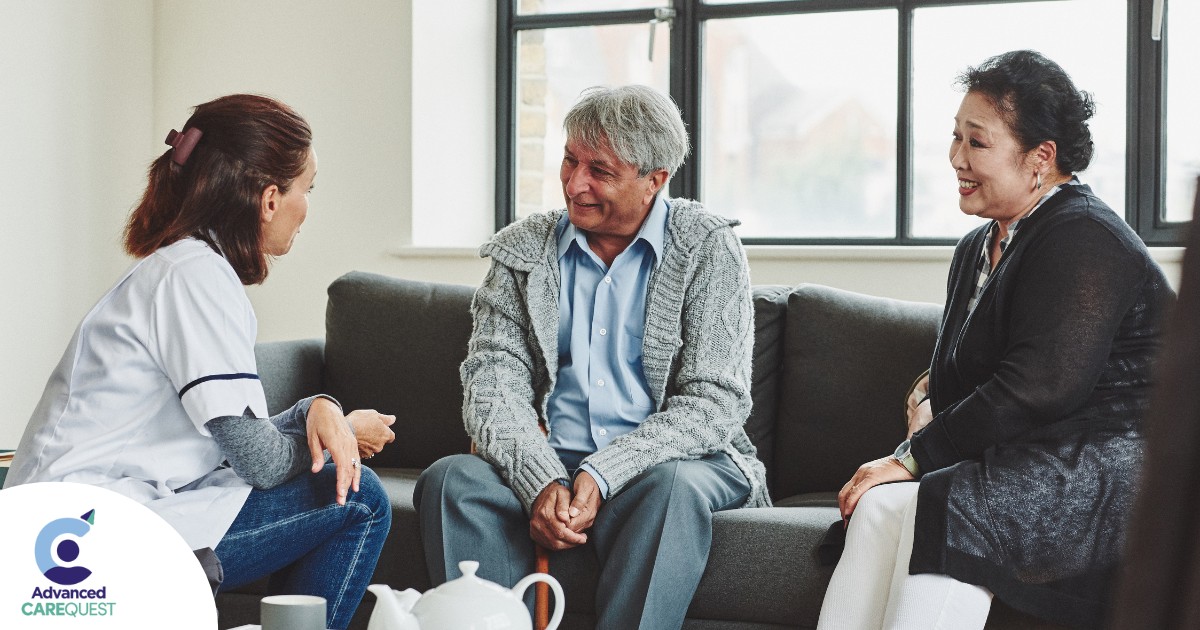 A caregiver talks with an elderly couple representing the kind of communication that professional caregivers need to have to anticipate client needs.