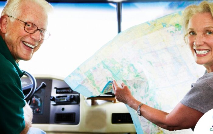 An older couple looks back smiling from the front of an RV, representing how day trips for seniors can help boost the mood of everyone.
