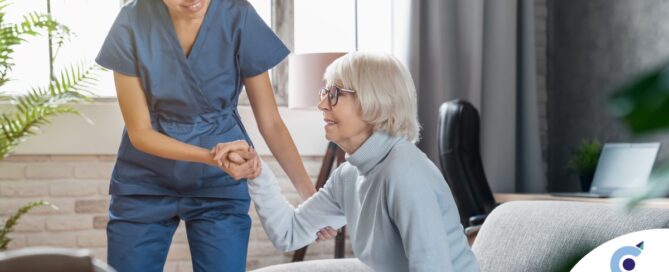 A caregiver demonstrates her caregiver skills by helping an older adult get up.