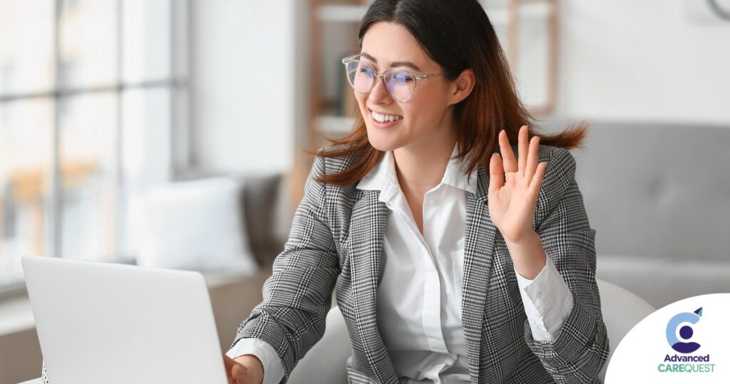 A well-dressed woman smiles and says hi on a videoconference, representing a candidate who is well-prepared for a caregiver interview.