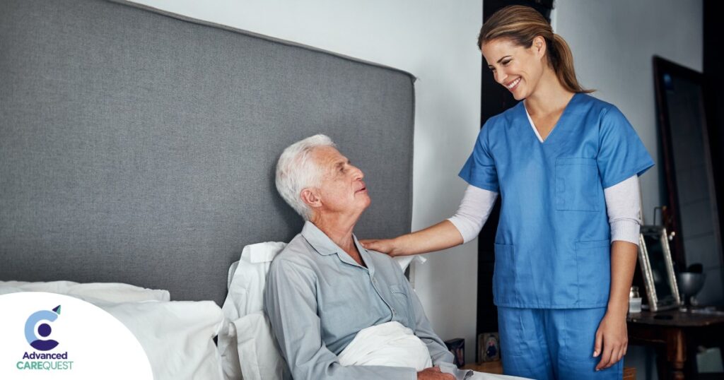 A caregiver smiles at an older client in bed, representing the compassion involved in being a live-in caregiver.