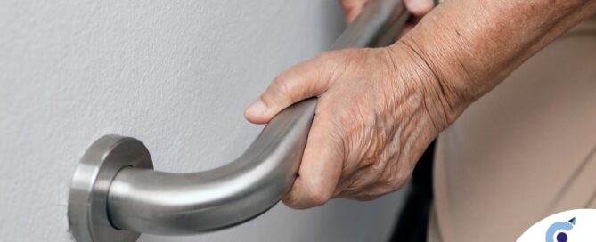 An older adult uses a grab bar representing one of the home modifications that is helpful for fall prevention for elderly adults.