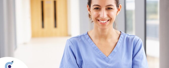 A woman in scrubs smiles, representing the good results that can come when caregivers branch out to become CNAs.
