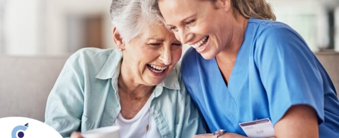 A woman in scrubs laughs with a senior woman, representing how caregiving can be a great career choice.