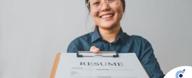 A woman happily hands in a resume, representing a successfully written caregiver resume.