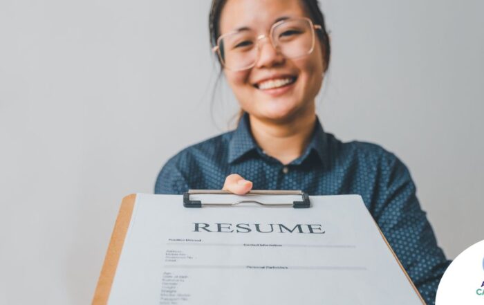 A woman happily hands in a resume, representing a successfully written caregiver resume.
